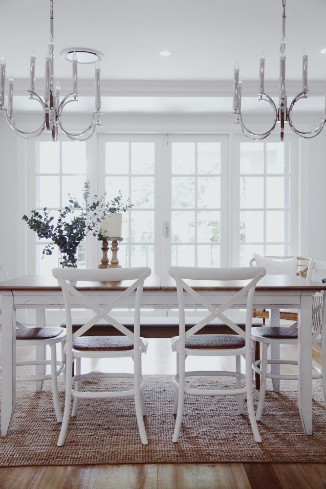 Shack Hamptons dining table and dining chairs with french doors and light white room and centre piece