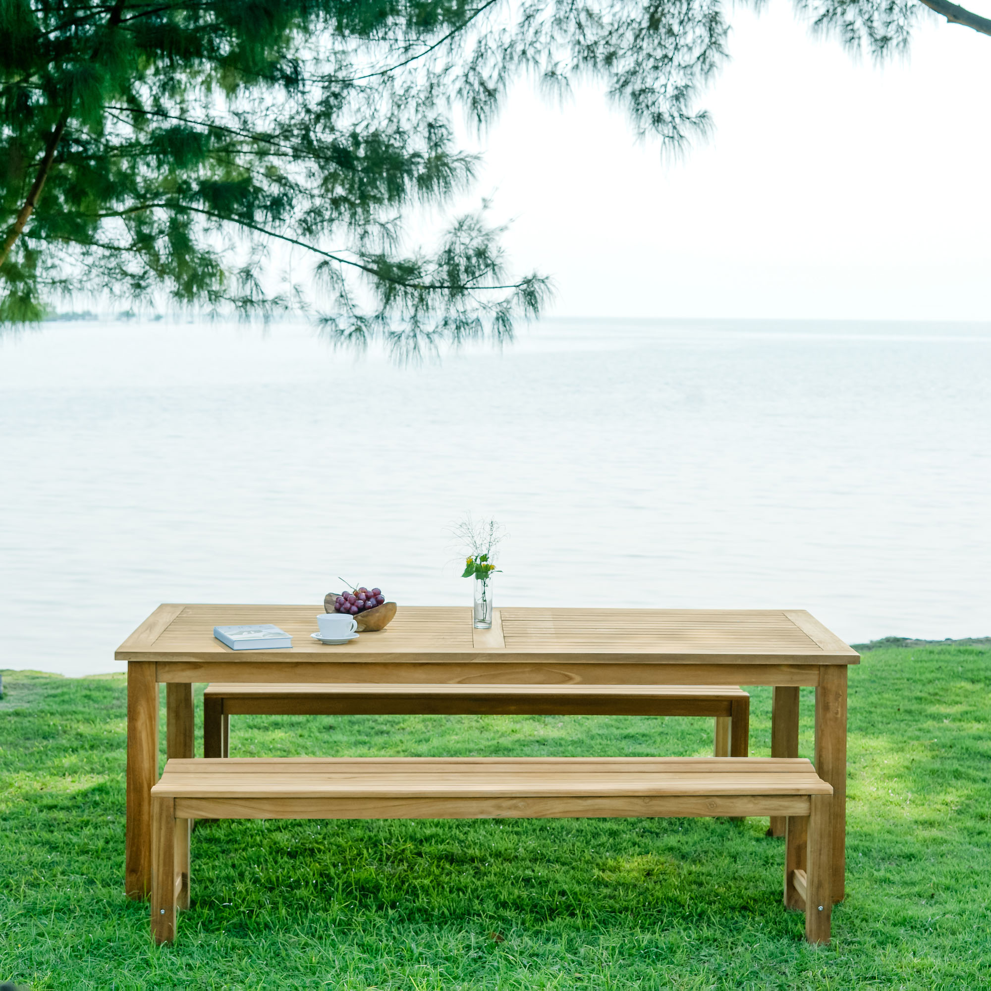 Balmoral Outdoor Teak Dining table + Bench a on grass by water